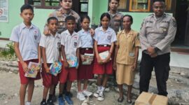 Ket Foto : Kapolsek Malaka Tengah Ipda Harris Islamy Pasya S.Tr.K, bersama anggota membagikan buku tulis bagi siswa SD di Malaka, Senin 14/4/2025/dok Polsek Malaka Tengah/Timornesia 