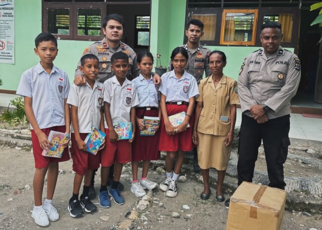 Ket Foto : Kapolsek Malaka Tengah Ipda Harris Islamy Pasya S.Tr.K, bersama anggota membagikan buku tulis bagi siswa SD di Malaka, Senin 14/4/2025/dok Polsek Malaka Tengah/Timornesia 