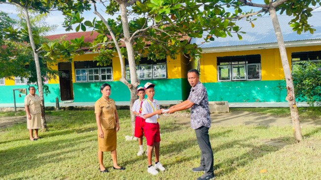 Kepala Sekolah SDI Kleseleon Agustinus Seran memberikan hadiah kepada dua siswa yang membela SSB Weliman di Piala Bupati Malaka Seri I tahun 2026/dok A's/Timornesia